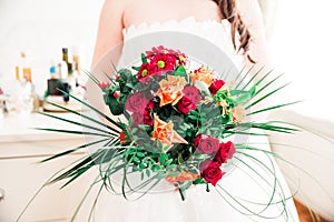 Newly Wed Woman Holding her Red, Orange and Green Bridal Bouquet