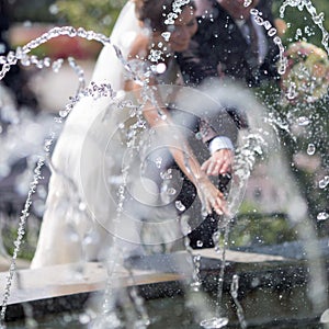 Newly wedded behind fountain