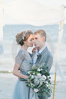 Newly-weds cuddling at the seashore