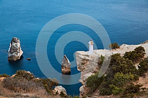 Newly-weds enjoy beautiful ocean view on cliff. Calm sea and water texture. Nature and festive event idea, copy space