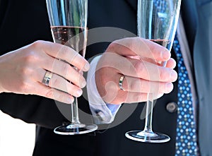 Newly weds hands with wedding rings and champagne