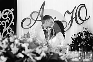 The newly-weds kiss with champagne