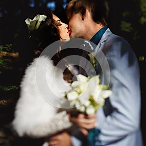 The newly-weds kisses in the sunshine