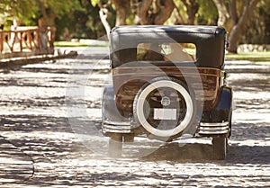 A newlywed couple is driving a convertible retro car