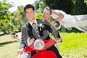 Newlywed couple enjoying scooter ride