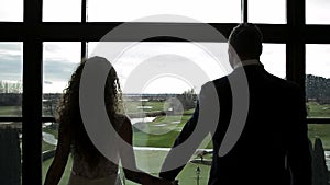 Newlywed couple holding hands looking out the window. HD 24FPS.