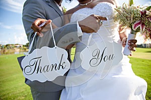 Newlywed couple with thank you sign