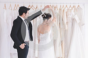 Newlywed cute bride and groom hold hand togher dancing in fitting room