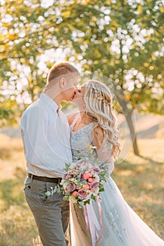 Newlywed`s kiss on wedding, the bride and groom sincerely show their feelings, the girl with the blond hairstyle in a