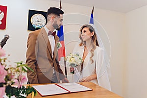 Newlyweds append signatures in a registry office during wedding registration.