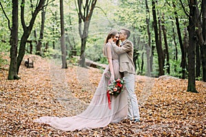 Newlyweds in an autumn romantic forest. Wedding ceremony outdoors.