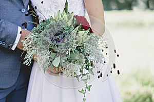 Newlyweds with a bouquet of artichokes and decorative cabbage, closeup