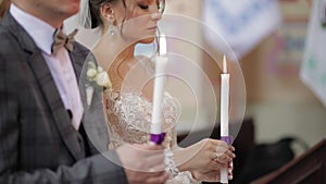 Newlyweds. Bride and the groom stand in church, holding candles in their hands. Wedding ceremony