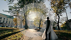 Newlyweds' dance in the city's Autumn Park. The groom takes the bride in his arms.