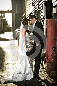 Newlyweds embracing against a red box