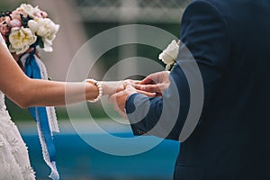 Newlyweds exchange rings, groom puts the ring on the bride`s hand. photo