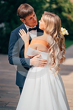 newlyweds. groom and bride in traditional wedding clothes cuddling in park