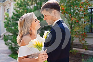 newlyweds. groom and bride in traditional wedding clothes cuddling in park