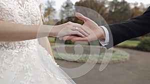 Newlyweds. Hands of groom with bride in the park. Wedding couple. Happy family