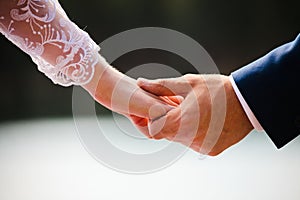 The newlyweds hold hands.