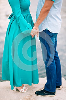 Newlyweds hold hands on the sea. Couple holding hands. Wedding i