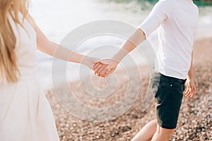 Newlyweds hold hands on the sea. Couple holding hands. Wedding i