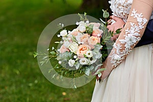 Newlyweds hold the wedding bouquet in their hands