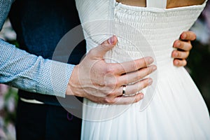 Newlyweds are hugging. Close up. The hands of bridegroom`s husband embrace woman`s. Wedding, engagement, marriage proposal, dati