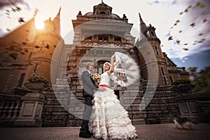 Newlyweds are hugging near the ancient castle