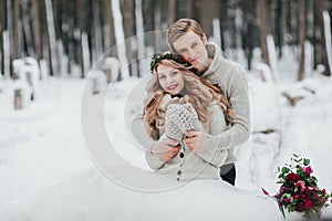 Newlyweds are hugging in the winter forest. Couple in love. Winter wedding ceremony.