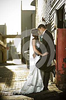 Newlyweds kissing passionately against a red box