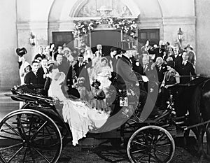 Newlyweds leaving wedding in carriage