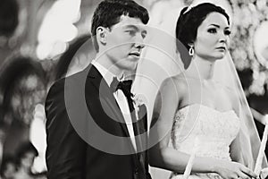 Newlyweds look musing during a ceremony in the church