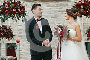 Newlyweds looking at each other joyfuly during the ceremony