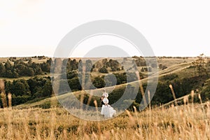 Newlyweds in love. The groom holds the bride in his arms. Beautiful view of nature