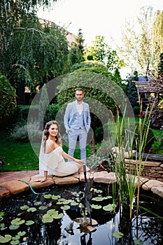 newlyweds near an artificial pond in a summer park. wedding photo shoot.