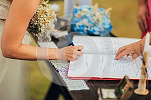 Newlyweds put their signatures in the act of registering a marriage