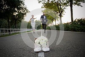 Newlyweds run to distill for a bouquet of brides photo