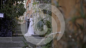 Newlyweds taking pictures on the street. Action. A young couple with a bride in a white dress and a man in a suit who