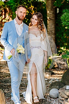 newlyweds on a walk in a summer park. wedding photo shoot.