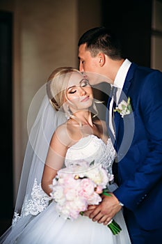 The newlyweds are walking in the park on the wedding day. The bride and groom Enjoying at the wedding day. Sunny weather.