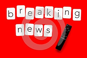 News concept. Breaking news. TV remote on red background top-down