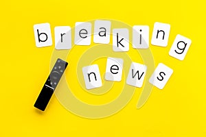 News concept. Breaking news. TV remote on yellow background top-down