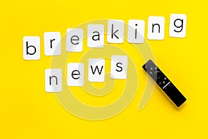 News concept. Breaking news. TV remote on yellow background top-down