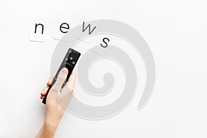 News concept. TV remote in hand on white background top-down copy space