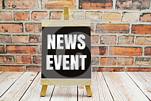 News Event text on the blackboard set on wooden floor and brick background