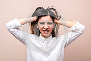 News influence. portrait of young annoyed businesswoman in white shirt with collar pulling her hairs and getting crazy