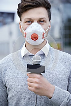 News reporter wearing a prevention mask and speaking into a microphone