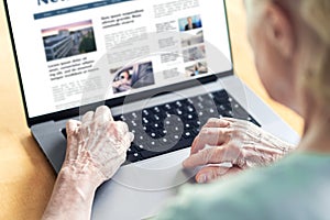 News website in laptop of an old woman. Elder senior and grandma reading digital newspaper with computer. Online magazine.