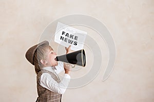 Newsboy shouting against grunge wall background. Boy selling fake news